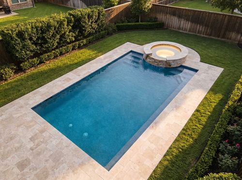 Rendering of a rectangular pool with an attached spa spilling into it at dusk