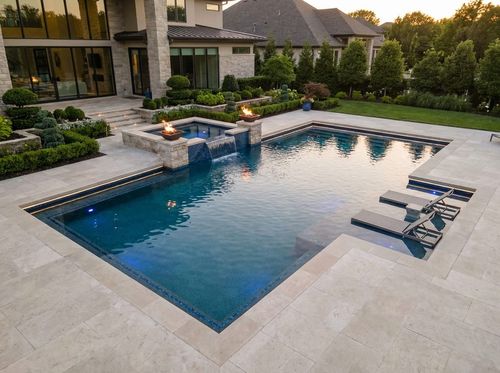 Rendering of a luxury geometric pool with a raised spa, water wall, fire bowls, and lighting at dusk