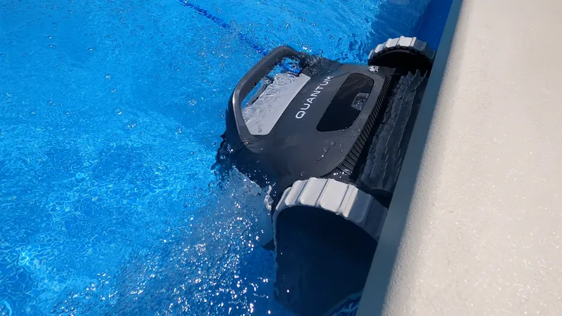 A robotic cleaner being tested along the pool waterline