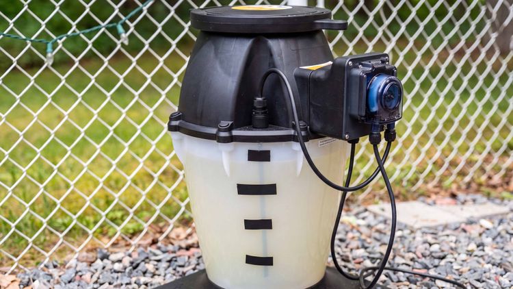 The IntelliChem tank and dosing pump up close — the tank holds plain liquid chlorine and the peristaltic pump meters it out