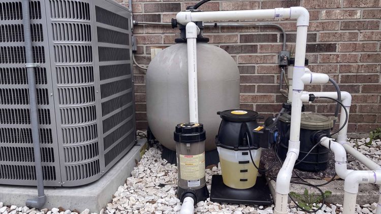 An IntelliChem-style closed-loop setup on the equipment pad — the controller reads the water and the pump doses to match