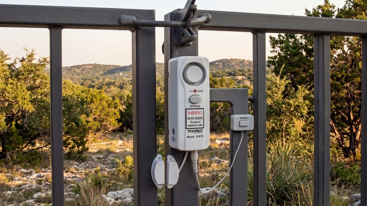 The TECHKO S187D mounted high on the gate — out of reach of little hands