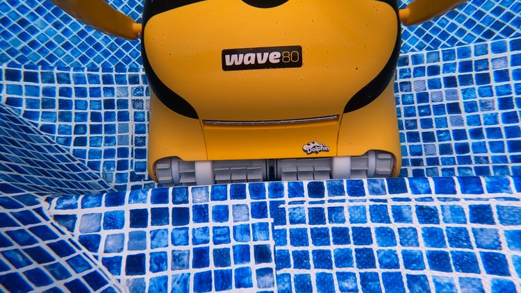 The Wave 80's active front brush scrubbing along a pool step