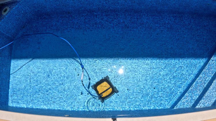 The corded Wave 90i crossing the pool floor with its cable trailing behind