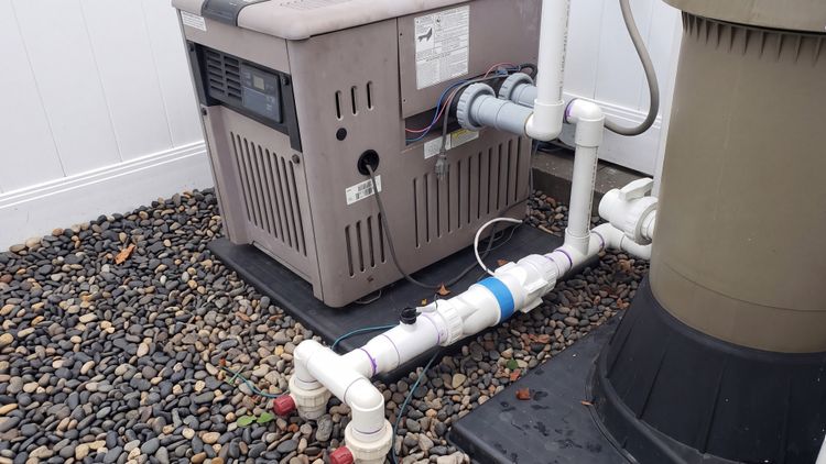 A right-sized Hayward cell installed between the heater and filter on a mid-sized pool's equipment pad