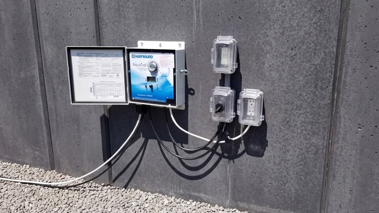 The two halves of a salt system: a wall-mounted power center (the brain) that drives the inline salt cell (the chlorine factory)